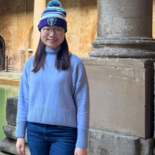 A female student standing in front of a concrete column