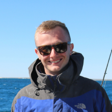 A male student standing on a boat