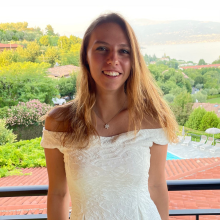 A student standing with trees in the background