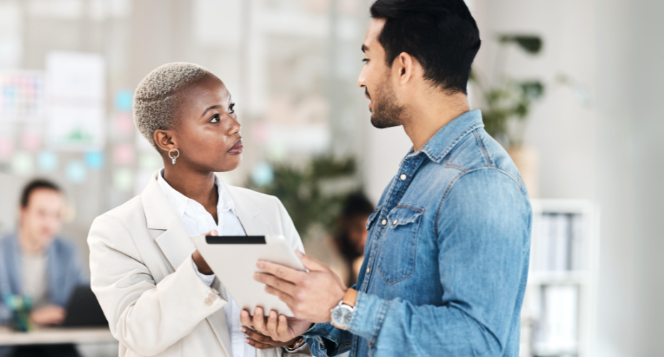 Woman talking to a man who is holding a tablet computer