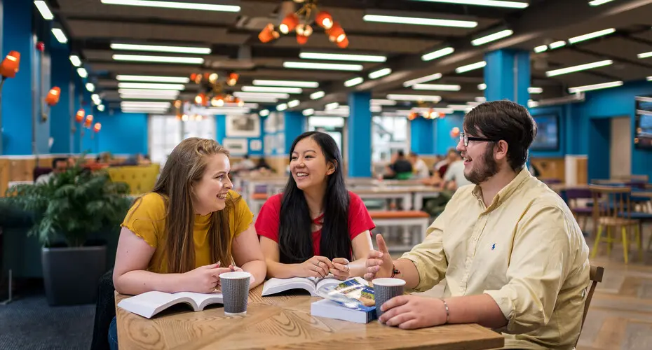 Three students studying and having coffee together on campus