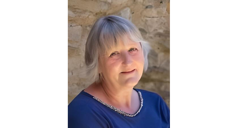 Headshot of cathy whapham against stone wall.