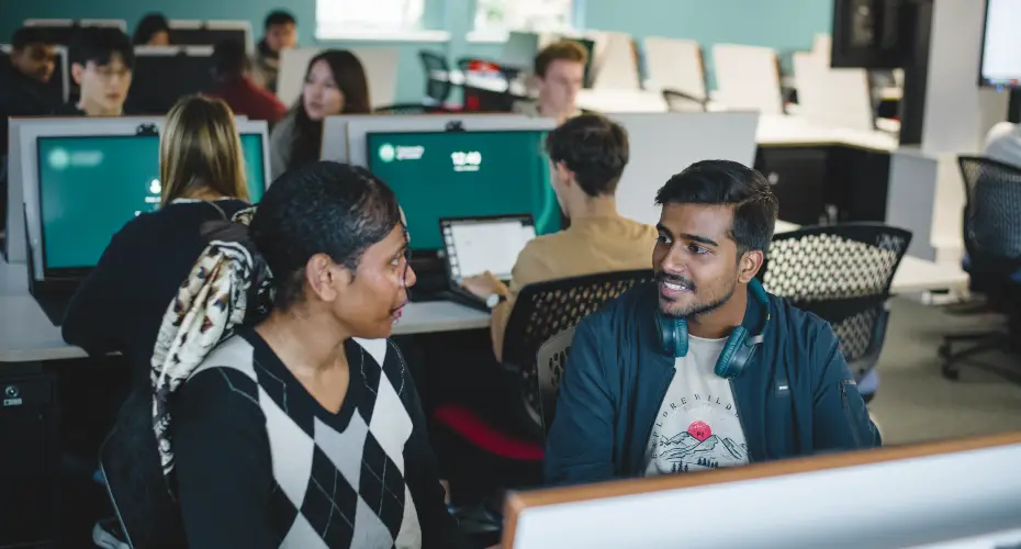 Two students sitting at desks next to each other in the Babbage computer lab