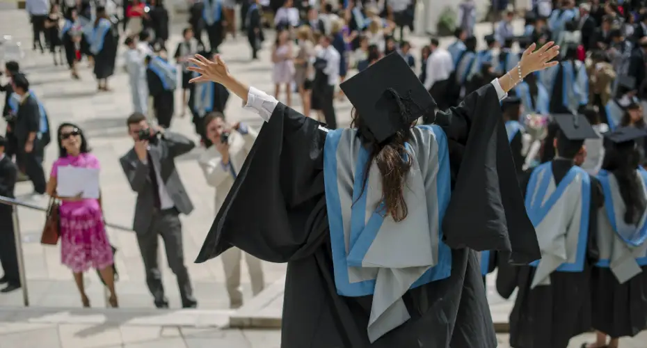 A student celebrating her graduation on our iconic Forum North Piazza