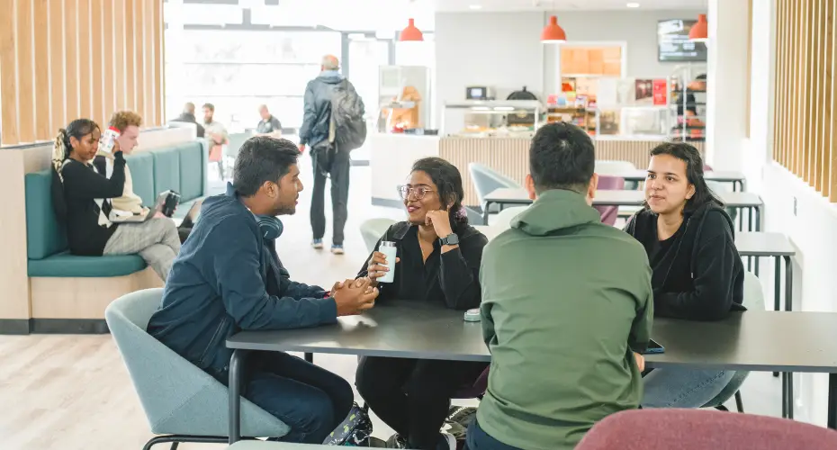 Group of students enjoying refreshments in the social space near Babbage computer lab