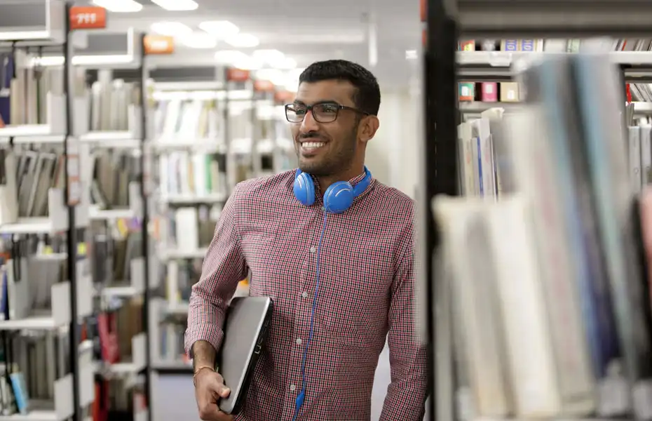 A Degree Apprenticeship student stood in the library