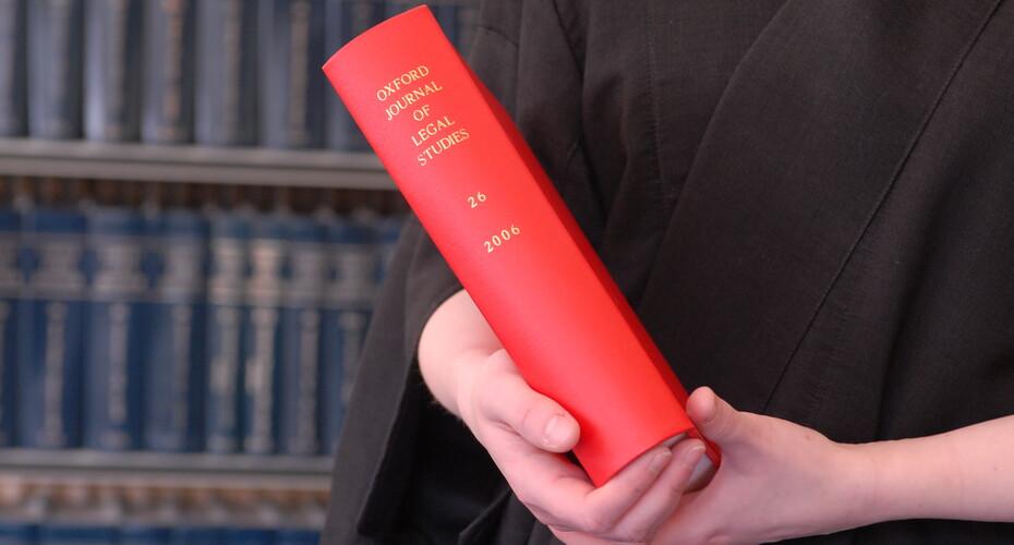 A lecturer holds a book in the Amory law library