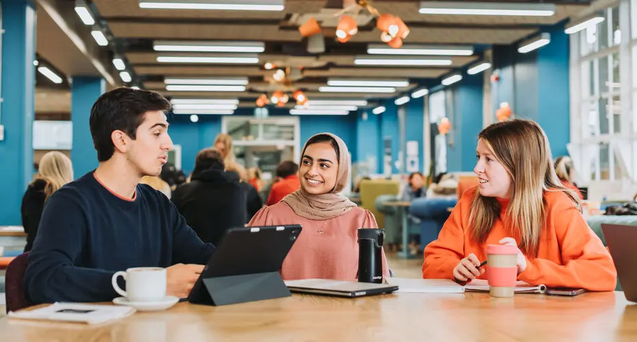 A group of students having a conversation at one of our on-campus cafes.