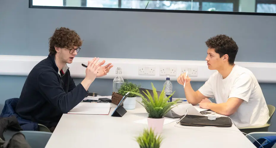 Two students working together in a study space on Streatham Campus.