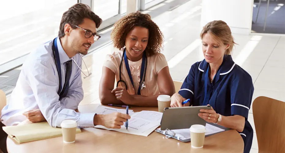 Three NHS staff working together at a table