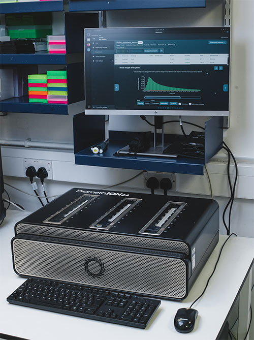 Computer screen and promethion sequencer in a lab
