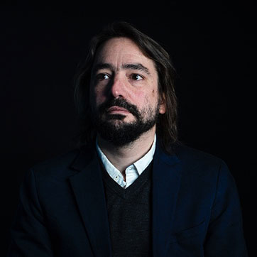 Dr Jean-Francois Mercure photograph against the dark background in studio lighting