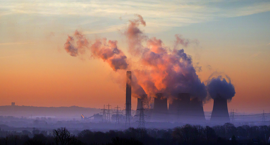 Sunrise over powerstation highlighting plumes of pollution in the morning light