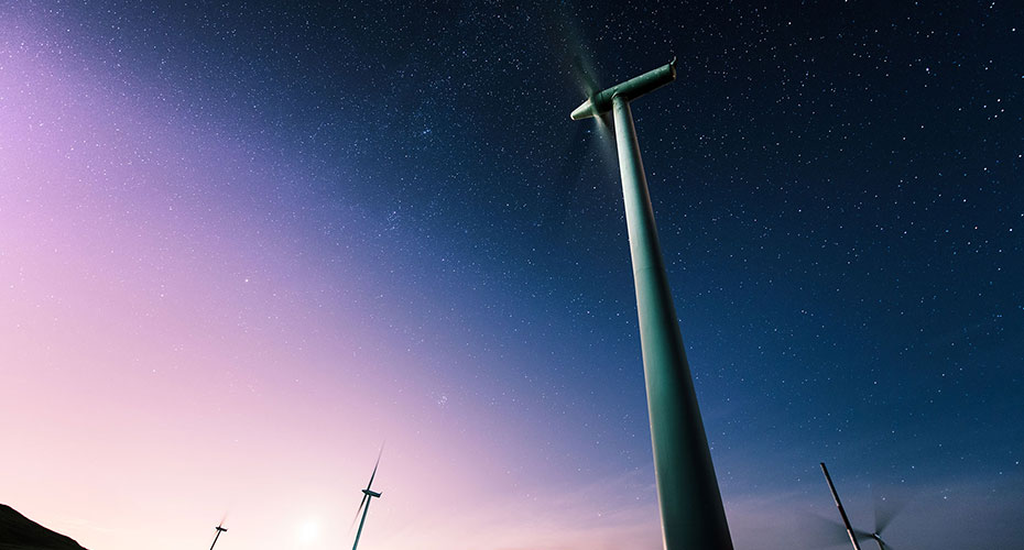A wind turbine under the stars. The angle in the lighting makes it feel like something from science-fiction.