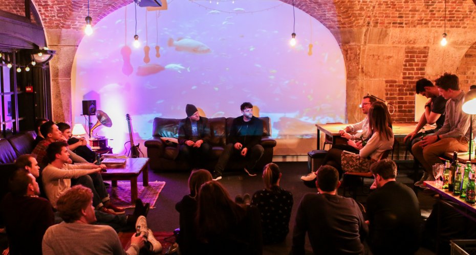 A group of people sitting in a room with a projector screen, attending an event organized by the alumni entrepreneurs network.