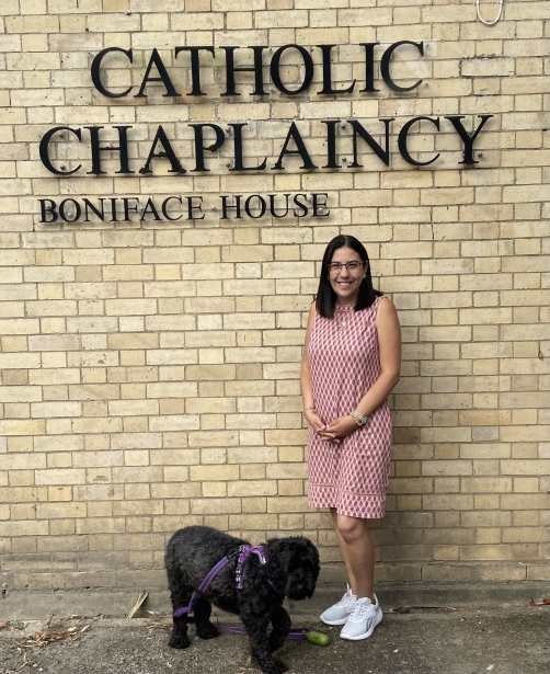 Mirtha Mangone standing outside the Catholic Chaplaincy, beneath a sign that reads 