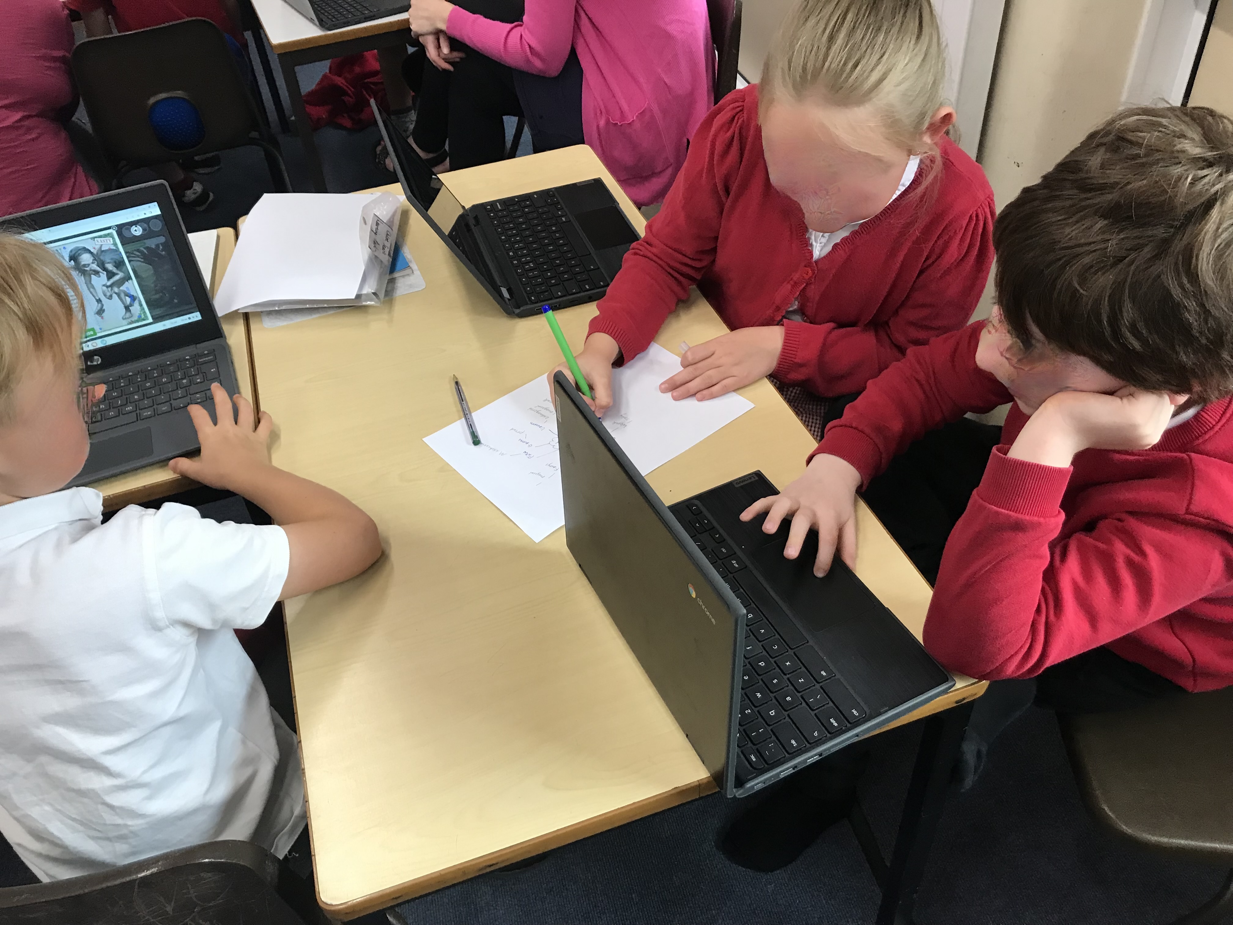 Children note making together on paper about characters on screen