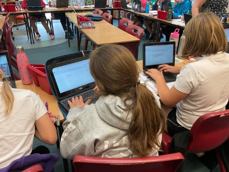 students typing up the story using Google Docs