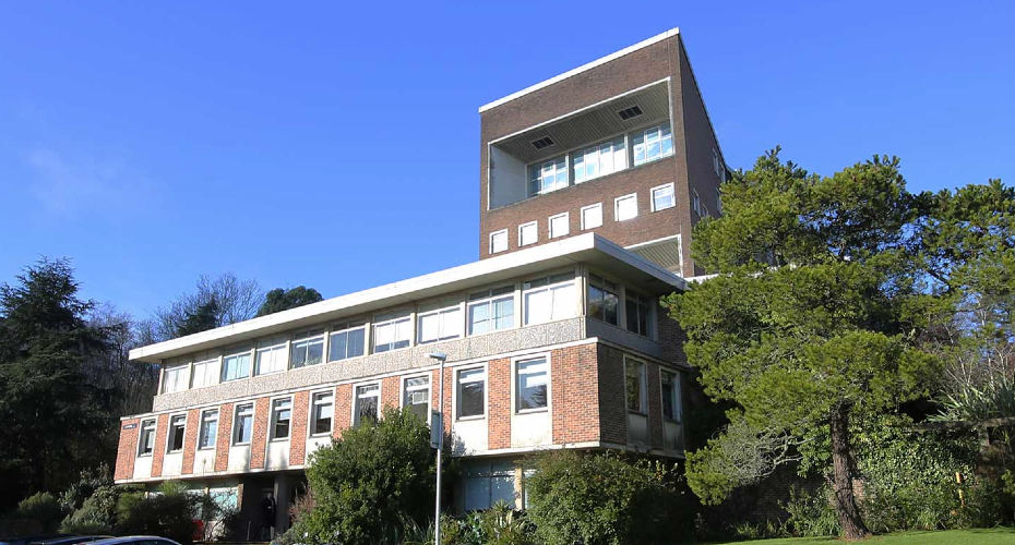 Laver building with blue sky and trees