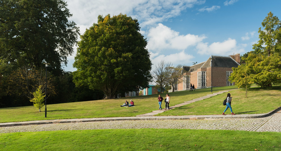 Students walking around streatham campus, with roborough studios in the background.