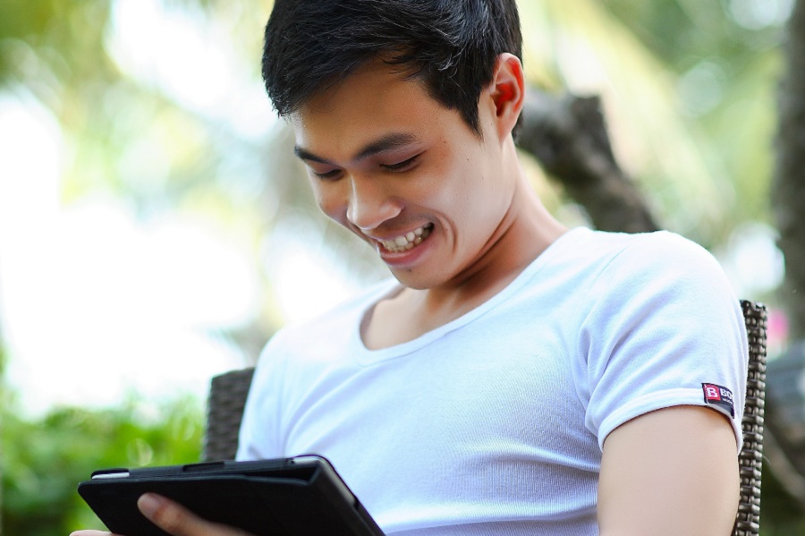 A man seated on a chair, smiling warmly, exuding a sense of happiness and contentment.