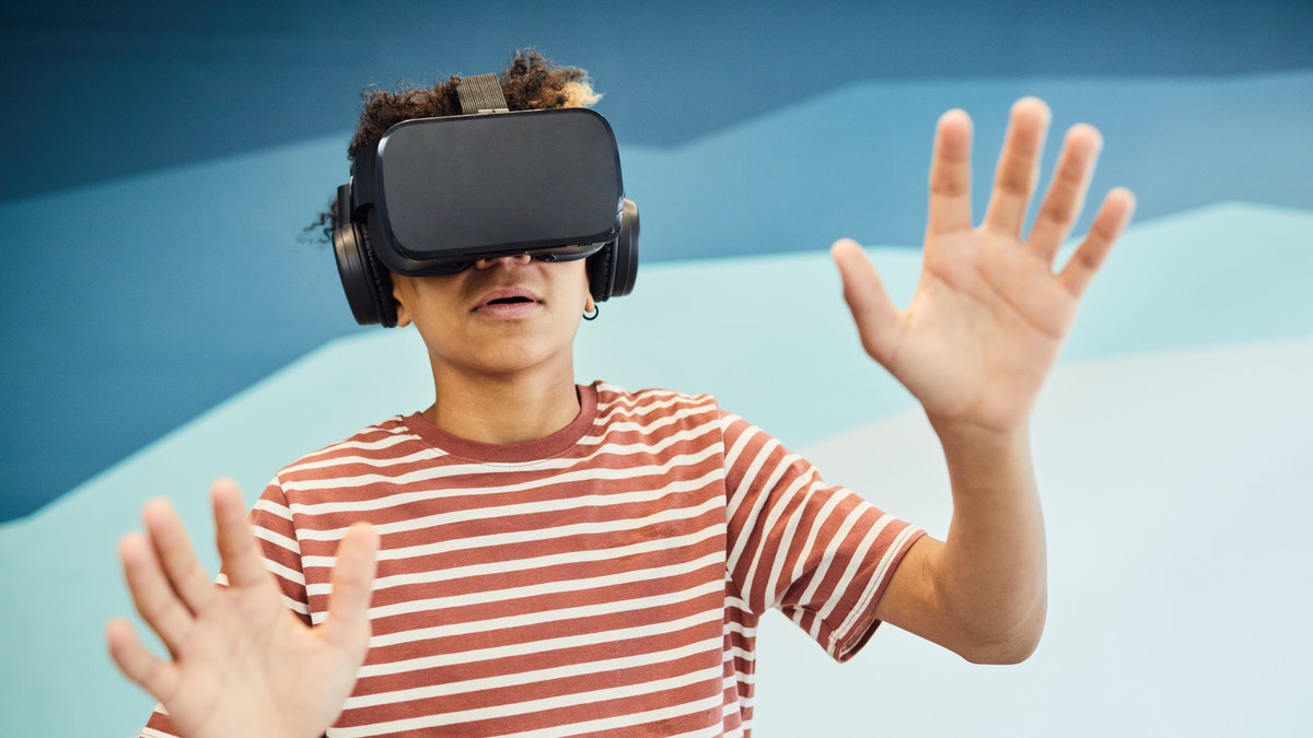 Someone in a striped t-shirt using a VR headset